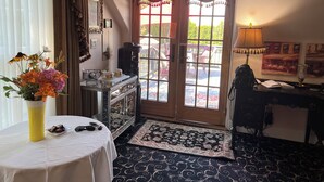 A room with a coffee station, a mirror, a rug, and a view of the outside. - The Villa Vista (Grandview)