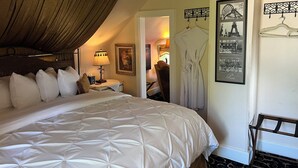 A hotel room with a large bed, a nightstand, a lamp, and a framed picture of the Eiffel Tower. - The Villa Vista (Grandview)