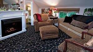 A living room with a fireplace, patterned carpet, and a sofa with leopard print cushions. - The Villa Vista (Grandview)