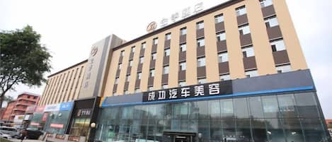 A hotel building with a sign for "Zhongxin Hotel" and a car dealership named "Success Car Beauty Salon" on the ground floor.