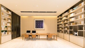 Una sala de reuniones moderna con una mesa larga, sillas y estanterías empotradas a ambos lados.