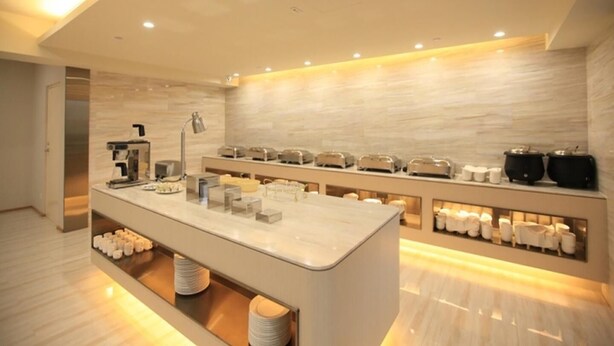 Habitación de hotel moderna con una encimera central tipo isla, cafetera y diversas comodidades, incluyendo una zona de té y espacio para artículos de aseo.