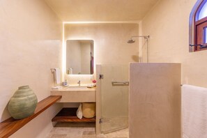 A bathroom with a shower, sink, and mirror.