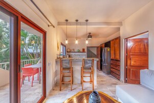 Una cocina moderna con armarios de madera, una isla central e iluminación colgante.