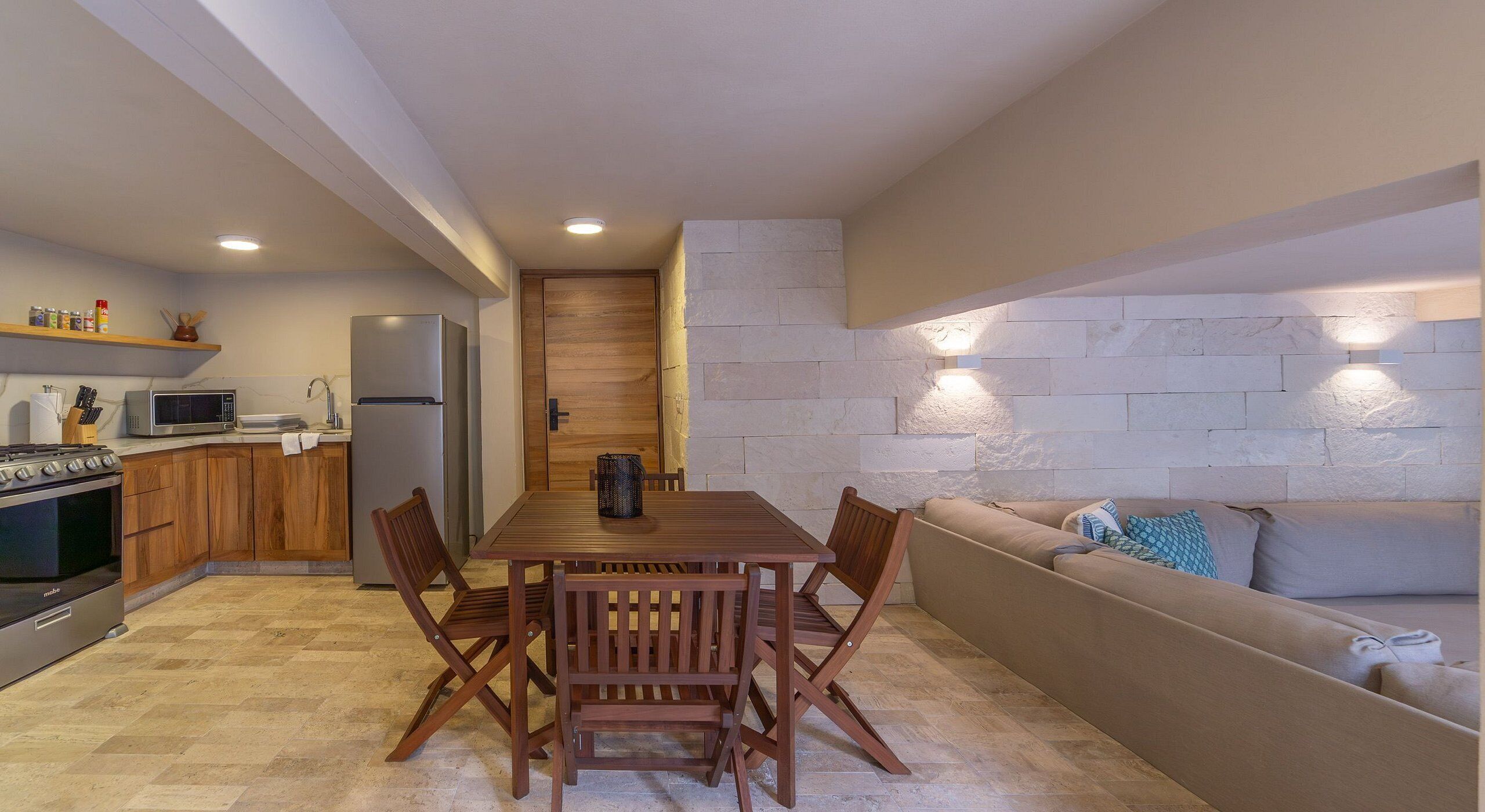 A compact kitchen with a dining area, a built-in oven, and a refrigerator.
