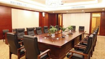 A conference room with a long table, multiple chairs, and a chandelier.