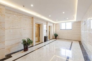 A spacious hallway with marble walls and a polished floor, leading to a door. - Jiangang Hotel (Qianshan)