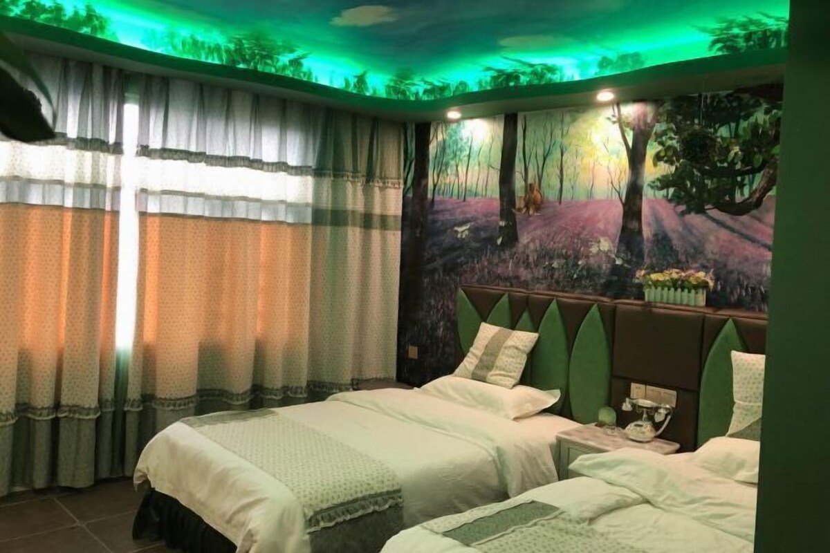 Ein Schlafzimmer mit zwei Betten, einem Nachttisch und einem Wandbild von einer Waldszene.