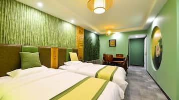 A hotel room with two beds, a desk, and a chair.