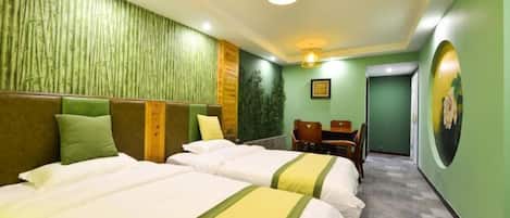A hotel room with two beds, a desk, and a chair.