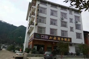 A multi-story building with a sign indicating a hotel. - Shanshui Business Hotel (Zhangjiajie)