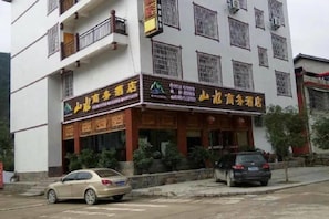 A two-story building with a storefront featuring signage in a foreign language. - Shanshui Business Hotel (Zhangjiajie)