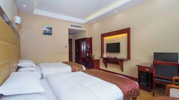 A hotel room with two beds, a TV, a desk, and a chair.