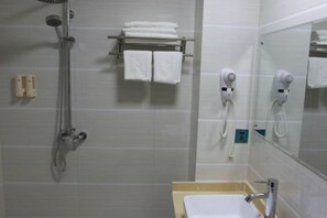 A bathroom with a shower, a sink, and two hair dryers mounted on the wall. - Shanshui Business Hotel (Zhangjiajie)