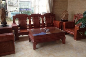 Ein Zimmer mit einem großen Holztisch, passenden Stühlen und einer Couch.