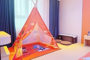 A room with a red and orange tent-like play area, a cat tree, and a small table. - Honglin Hotel (Foshan)