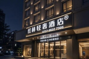 A hotel with a prominent sign displaying its name and contact number. - Honglin Hotel (Foshan)