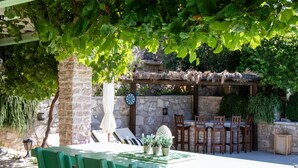 An outdoor dining area with a table and chairs, surrounded by stone walls and greenery. - Authentic Dalmatian Treasure Homes - House Stone (Orebic)