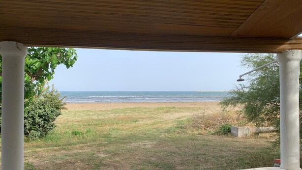 Un espace extérieur abrité offrant une vue sur la plage et l’océan.