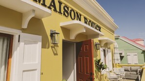 Un edificio amarillo con una puerta roja y un letrero que dice "MAISON ROUGE".