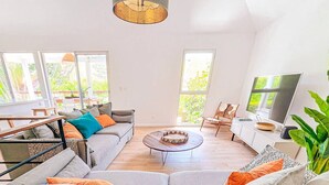 Un salon moderne avec un canapé gris, une table basse et un téléviseur.