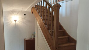 Eine Holztreppe mit einer weißen Tür am Fuß.