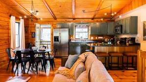 A cozy cabin-style interior with a dining area, kitchen, and living room. - Havenbrook~Rustic luxury, 10acres, hot tub (New Plymouth)