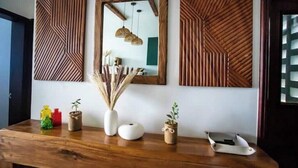 A wooden table with decorative items and wall art. - Rustic Haven Lakeside Condo (Entebbe)
