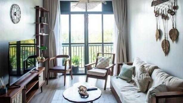 A cozy living room with a sofa, chairs, a coffee table, and a bookshelf. - Rustic Haven Lakeside Condo (Entebbe)