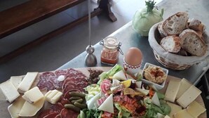 Une planche de charcuterie avec divers fromages, viandes et légumes.