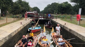 Un canal bordé d’écluses étroites, de bateaux et de passants.