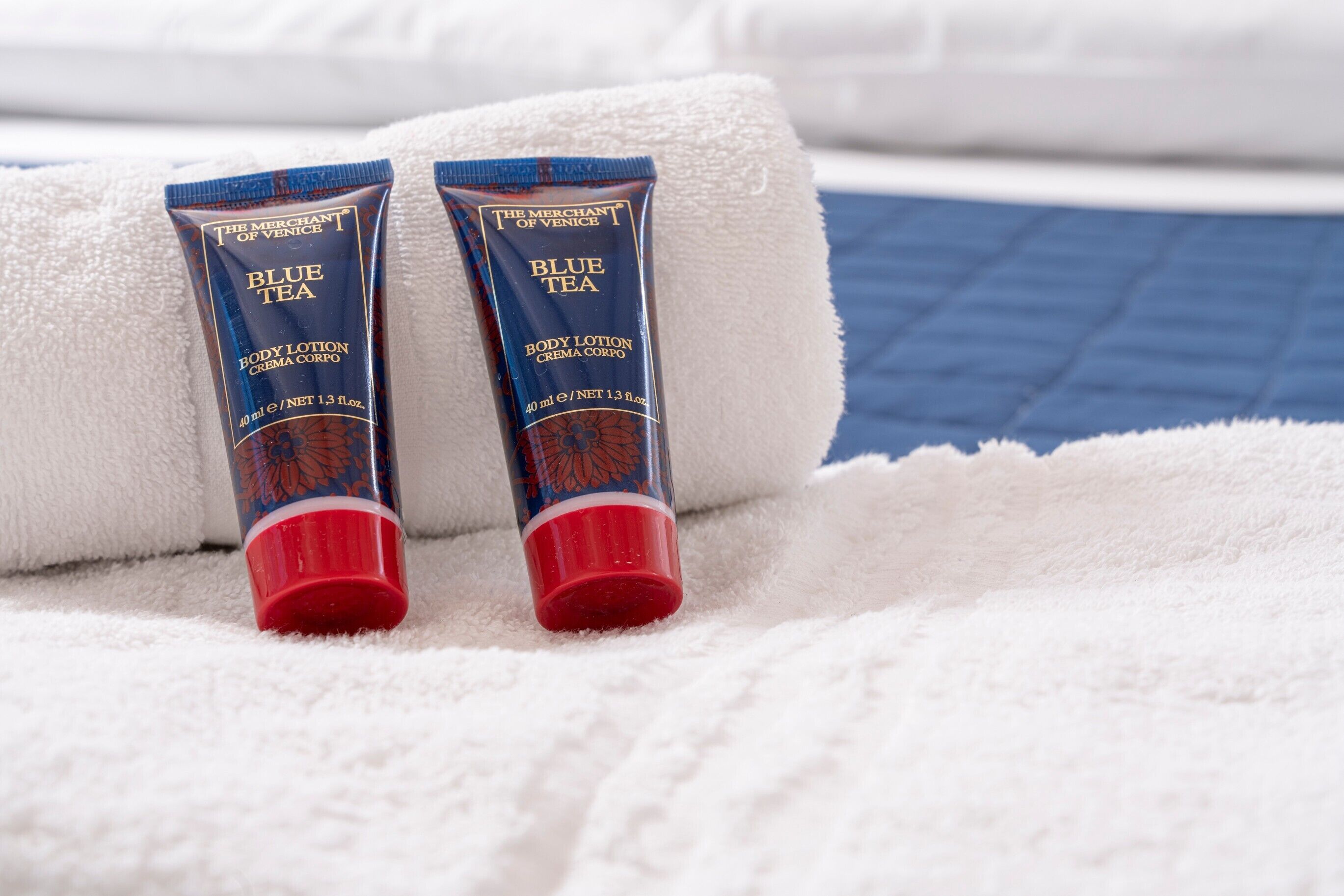 Two tubes of Blue Tea body lotion on a white towel.
