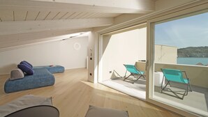 Een modern interieur met een balkon, een blauwe bank en uitzicht op zee.