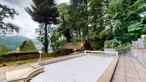 Relax by the serene pool surrounded by lush greenery and rolling hills.