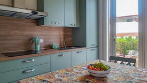 Eine moderne Küche mit Einbauofen, Spüle und Fenster mit Blick auf einen Garten.