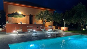 Ein Poolbereich mit Liegestühlen und einer Bar.
