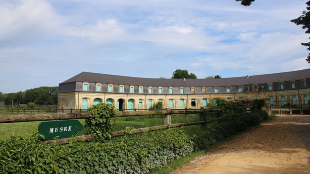 A large, historic building with a symmetrical facade, multiple arched windows, and a sign indicating it is a museum. - Gîte ô Naturel - nature and comfort getaway (Buzancy)