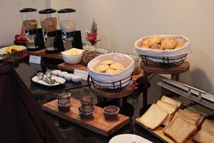 Un bufé de desayuno con diferentes alimentos y utensilios.