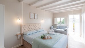 A bedroom with a large bed, a sofa, and a window. - Finca Mojito Cómpeta by Ruralidays (Málaga)
