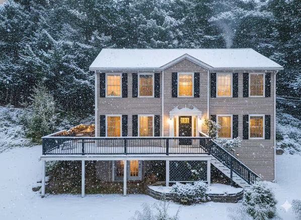 A two-story house with a balcony, a covered porch, and a staircase leading to the entrance.