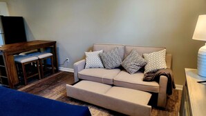 A living room with a sofa, a coffee table, and a TV stand. - New for 2026. Private driveway and new private entrance. (Mystic)