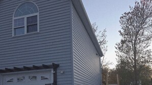 A single-story building with a garage, a covered porch, and a gravel driveway. - New for 2026. Private driveway and new private entrance. (Mystic)