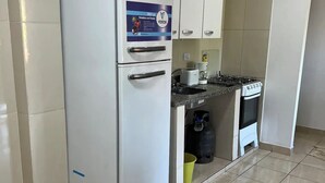 A kitchen with a white refrigerator, a gas stove, and a sink.