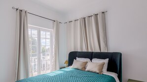 A bed with a teal quilted bedspread, white pillows, and a dark headboard. - Holiday Home 'Alojamento Local Coruche Erra' with Lake View, Wi-Fi and Air Conditioning (Coruche)