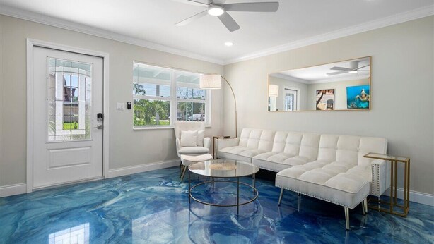 A living room with a white sectional sofa, a round coffee table, a white armchair, a floor lamp, and a ceiling fan. - Modern 2BR-Hot Tub/Pergola/Games (West Palm Beach)