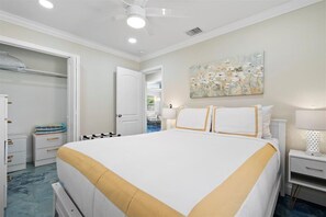 Une chambre d’hôtel avec un grand lit, une armoire, une table de chevet avec une lampe et un tableau au mur.