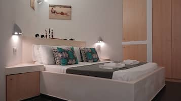 Un dormitorio moderno con cama, mesitas de noche, armario e iluminación en la pared.