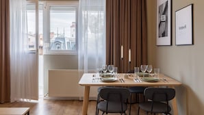 A dining area with a table set for four, a radiator, and a window with curtains.