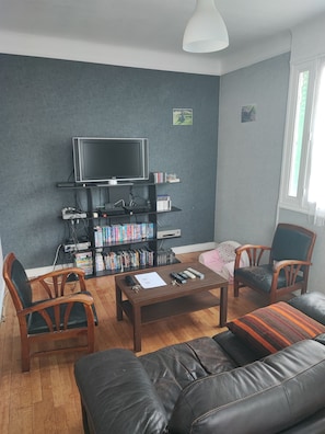 A living room with a TV, bookshelves, a coffee table, and leather sofas. - Detached house (Franconville)