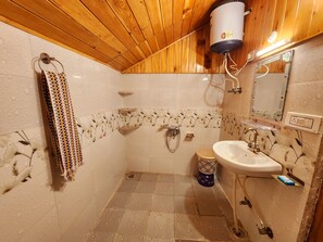 Bathroom features a sink, shower with handheld showerhead, and towel rack.